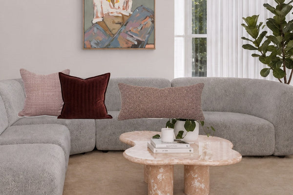 Blush and burgundy cushions on a grey sofa, styled with the norsu cushion combo builder