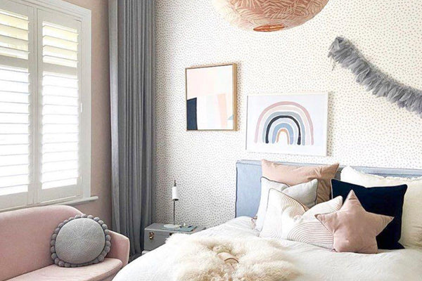 Cozy bedroom with pastel decor featuring a white bed, pink and navy pillows, soft lighting, and wall art in norsuHOME 1 - Painting style