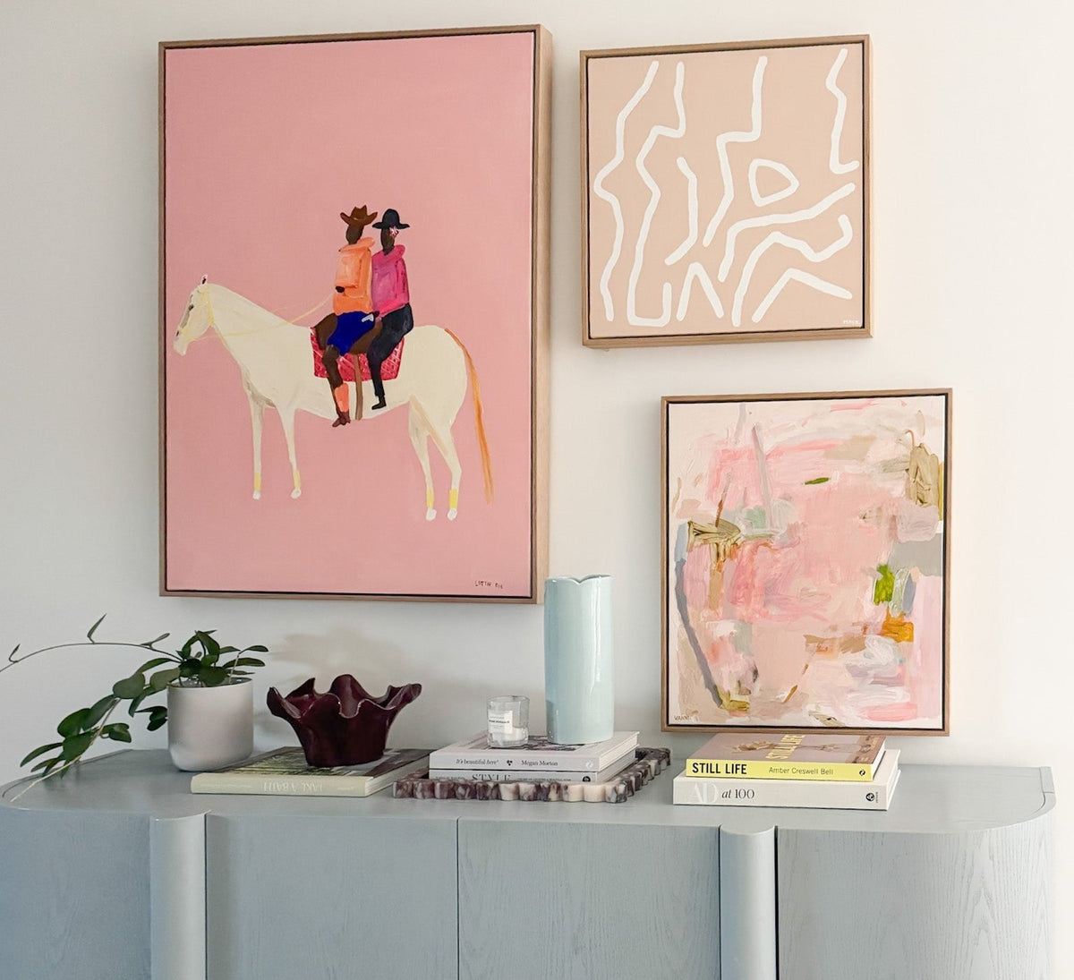 Limited edition art hung at eye level above a console in a styled norsu interior