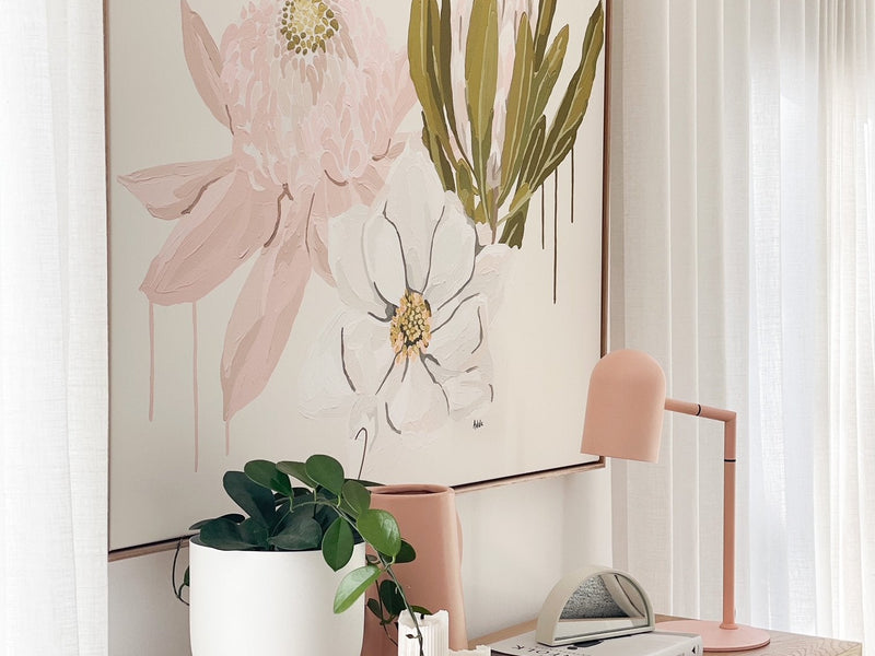 Adele Naidoo Native '21 collection botanical floral canvas print in soft pastels above wooden console with modern pink lamp and white vase with greenery