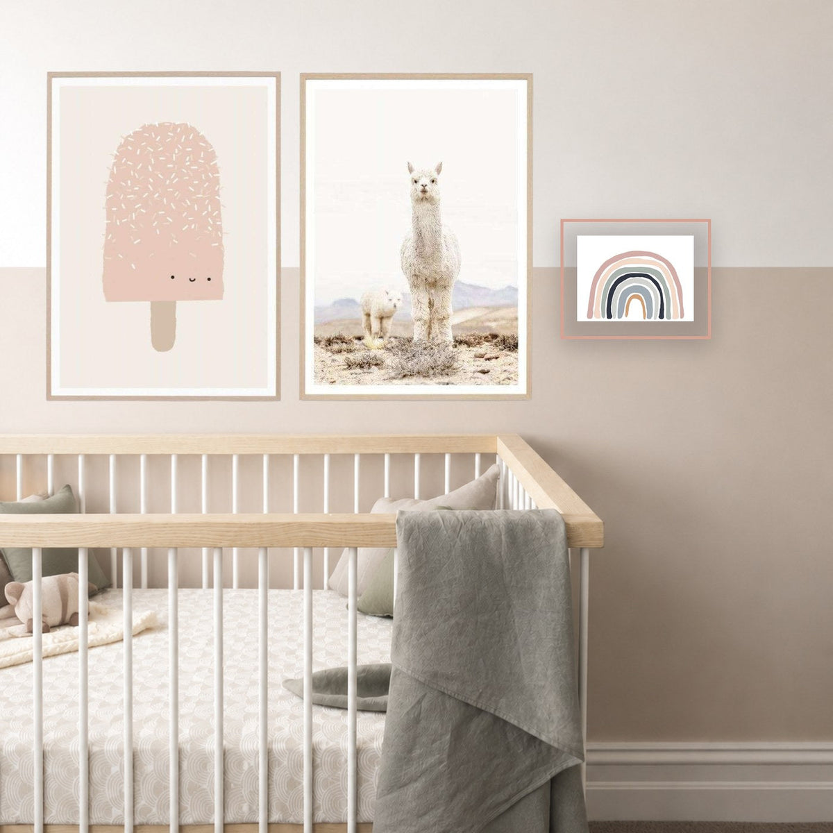 A nursery gallery wall — ice cream, llama and rainbow prints above a cot — arranged with the norsu gallery wall builder