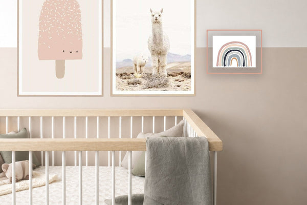 A nursery gallery wall — ice cream, llama and rainbow prints above a cot — arranged with the norsu gallery wall builder