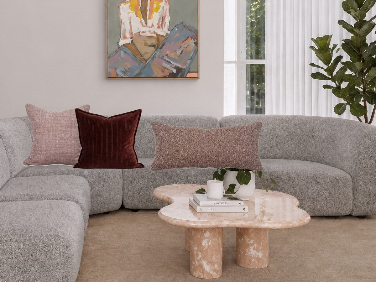 Blush and burgundy cushions on a grey sofa, styled with the norsu cushion combo builder