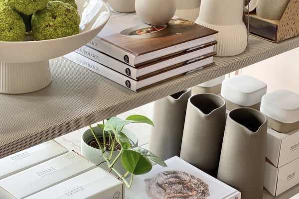 Minimalist white ceramic pitchers and vases with green plants on shelves from Robert Gordon range