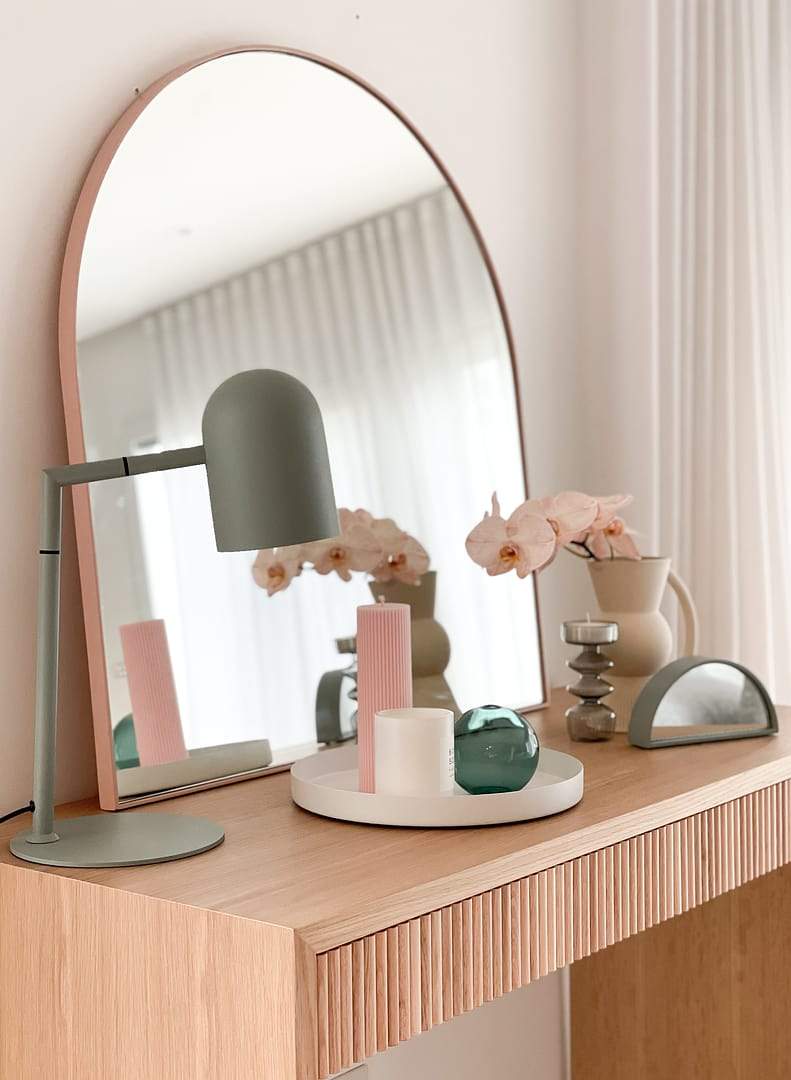 Styled wooden console table with round mirror, modern lamp, vases, and decorative objects for console like a PRO design