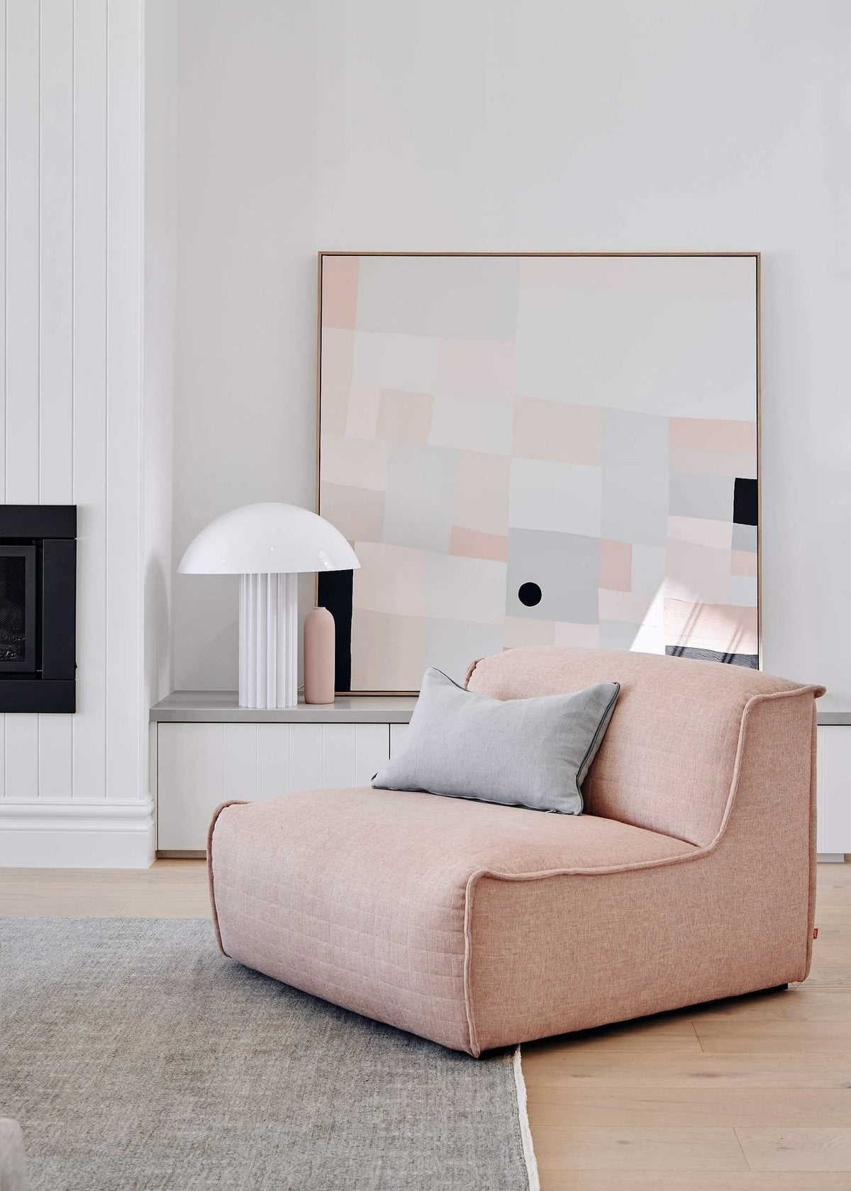 Pink lounge chair with gray pillow in a modern minimalist living room at Summerhill Residence styled by norsuHOME