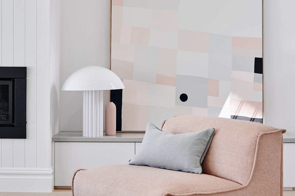 Pink lounge chair with gray pillow in a modern minimalist living room at Summerhill Residence styled by norsuHOME