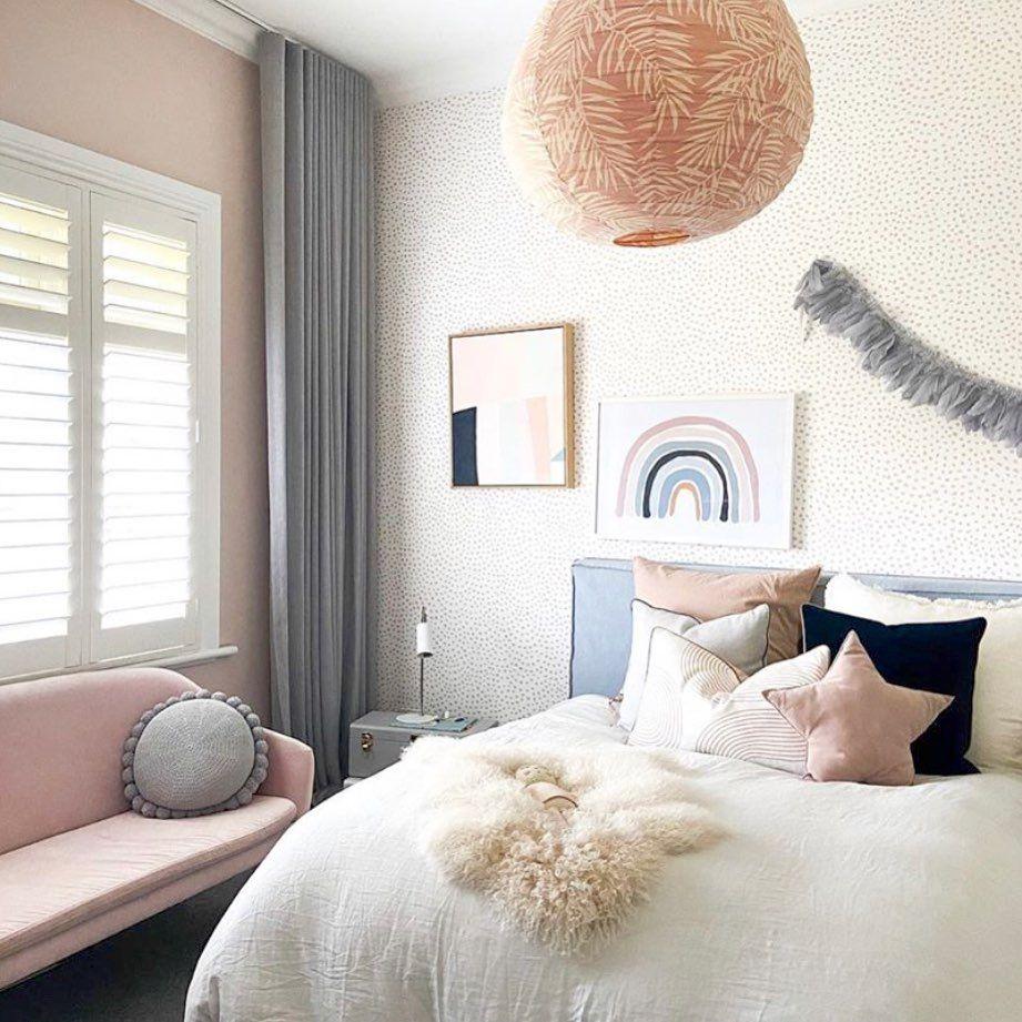 Cozy bedroom with pastel decor featuring a white bed, pink and navy pillows, soft lighting, and wall art in norsuHOME 1 - Painting style