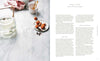 The Beauty Chef Gut Guide book by Carla Oates with recipes and gut health tips laid out on a marble table