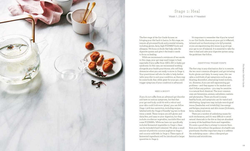 The Beauty Chef Gut Guide book by Carla Oates with recipes and gut health tips laid out on a marble table