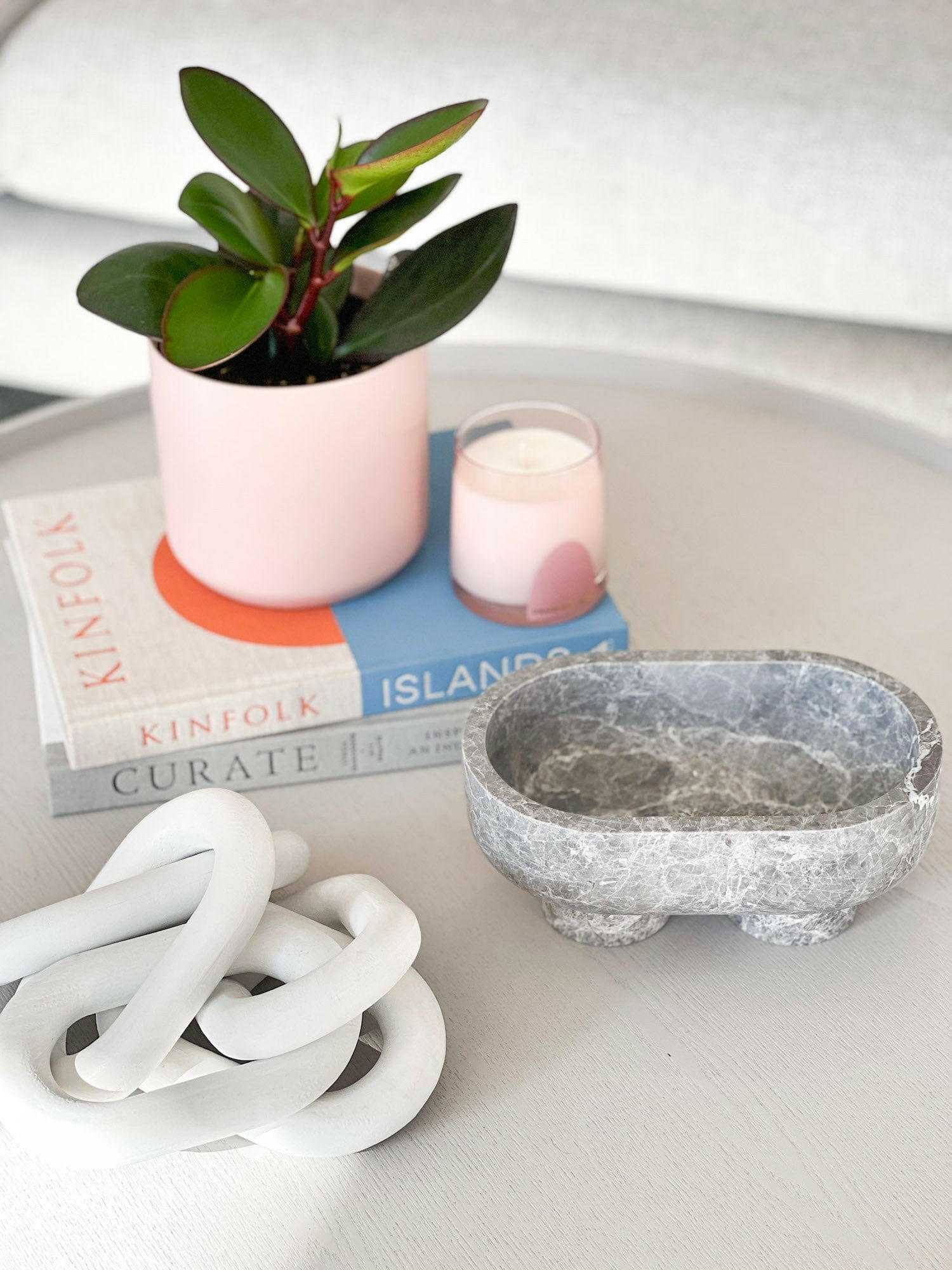CoTheory marble footed oval tray in tundra grey with sculptural design on white table with plant and decor items