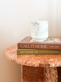 Stackable marble jewellery organiser canister on books on a marble table
