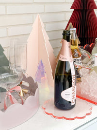 norsu Studio Perspex scallop trivet tray in ochre with champagne bottle and glasses on white surface