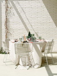 Set of 3 sage norsu Studio Perspex standing Christmas trees on a round table with white tablecloth and dining chairs in minimalist outdoor setting