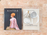 norsu Studio clear scalloped perspex tray with books and decor on marble surface