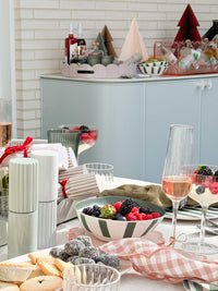 Davis & Waddell 4-piece dark green and mint green bamboo fibre bowl set with striped design on a table with berries and snacks