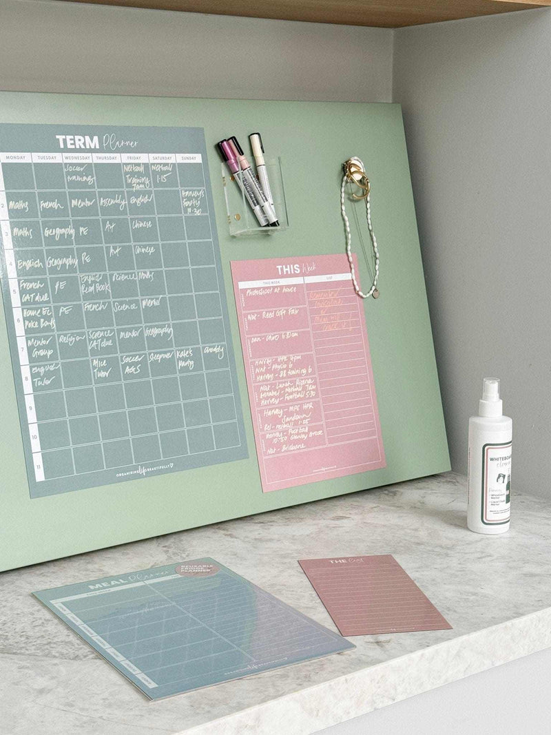 Blush magnet meal planner on fridge with weekly menu and marker pens for organized meal planning