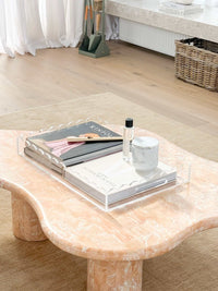 norsu Studio scalloped edge clear perspex tray on marble coffee table with books and decor