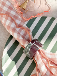 norsu Studio Linen blush gingham scallop-edged napkin with marble napkin ring on green striped plate