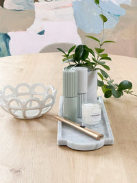 White Rye Stoneware Ceramic Basket with woven design on wooden table next to decorative tray and plants