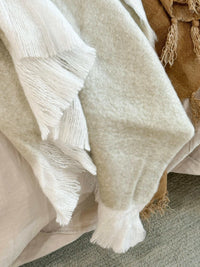 Off-white Baya Sorrento Throw with soft brushed wool texture and feathered fringe detail