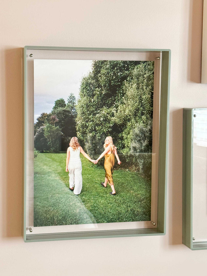 norsu STUDIO sage acrylic box gallery frame displaying photo of two women walking on grass in a park