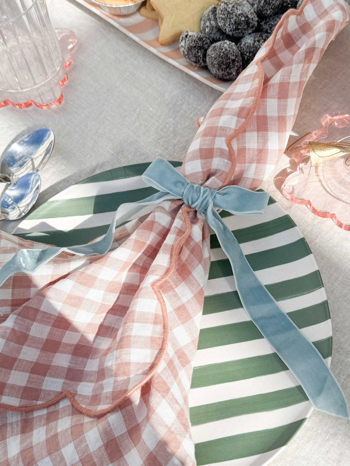 Davis & Waddell Saltara Bamboo Fibre Dinner Plate with dark and mint green stripes and gingham napkin with blue bow on table setting