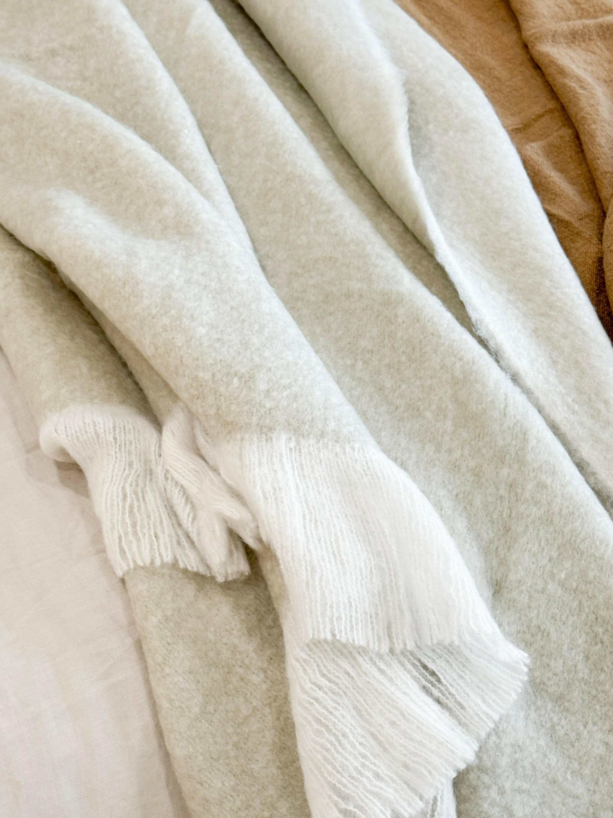 Baya Sorrento Throw in off white with soft brushed wool texture and feathered fringe detail