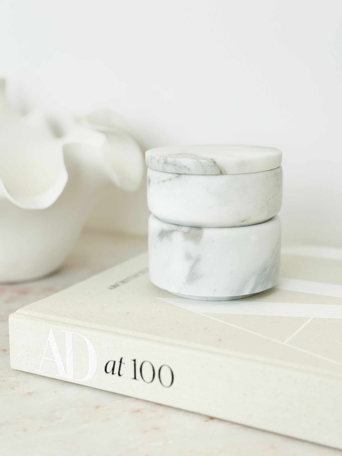Stackable marble jewellery organiser with cylindrical design and natural veining on a book.