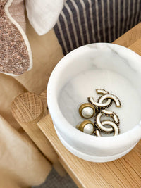 compact stackable marble jewellery organiser holding earrings on wooden surface