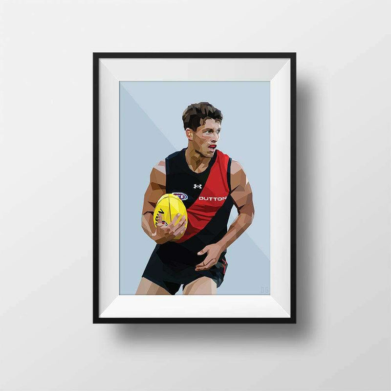 Framed DG Designs Dom Gauci kids art print of Archie Perkins AFL football player in Essendon jersey holding yellow football on powder blue background