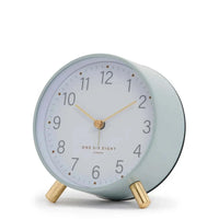 Maisie Silent Tick Alarm Clock in green with gold legs and hands, vintage-inspired design, silent ticking, and built-in alarm and nightlight.