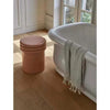 GlobeWest Hanson Round Stool in cherry ceramic glaze beside bathtub on wooden floor