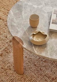 Willa Marble Coffee Table with natural travertine top and light oak elliptical legs in modern living room setting