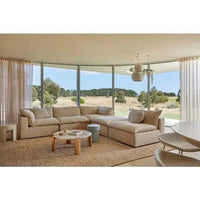 GlobeWest Hanson Round Stool in cherry ceramic glaze used as side table in modern living room with large windows and beige sectional sofa