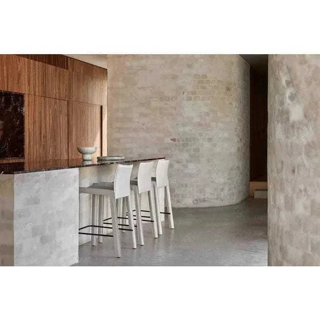 GlobeWest Rufus Indra Goblet Bowl in green onyx marble displayed on a kitchen counter with modern white stools.