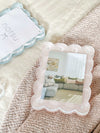 norsu Studio scalloped magnetic photo frame in blush with gallery-style depth and secure closure displaying a living room photo on textured surface