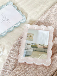 norsu Studio scalloped magnetic photo frame in blush with gallery-style depth and secure closure displaying a living room photo on textured surface