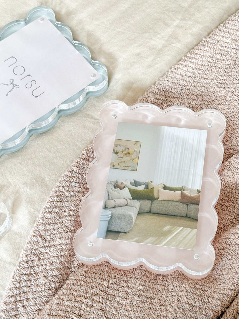 norsu Studio scalloped magnetic photo frame in blush with gallery-style depth and secure closure displaying a living room photo on textured surface