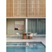 GlobeWest Seville Tile Oval Dining Table in pearl white with tiled oval base, set outdoors by pool with white chairs and modern decor