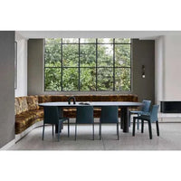 GlobeWest Seb Oval Four Leg Dining Table in oak veneer with three solid pillar legs in a modern dining room setting
