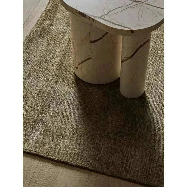 GlobeWest Tepih Neptune Rug in olive hand-woven wool blend with subtle rustic texture under marble table