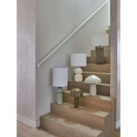 GlobeWest Emery Bodhi Table Lamp in dune sand with stacked geometric ceramic base and linen shade on wooden stairs