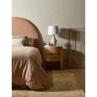 GlobeWest Lorne Shore Table Lamp with sandy chalk ceramic base and ivory cotton linen drum shade on wooden bedside table in muted bedroom setting
