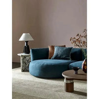 Dark teal Slipper modular sofa with curved design and plush cushions in stylish living room setting