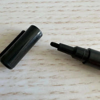 Black liquid chalk marker with fine tip and removable cap on wooden surface