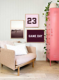 Customizable wall art prints with personalized number and color options in a stylish living space with sofa and pink locker