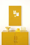 Mustard Made lockers magnetic storyboard with powder coated finish in mustard yellow above matching mustard yellow lockers with decor.