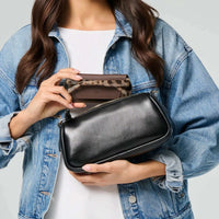 Woman holding a brown Fox and Leo glasses case with leopard print interior and a black leather bag.