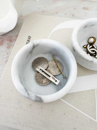 Stackable marble jewellery organiser with compact cylindrical design holding rings, coins, and hairpins.